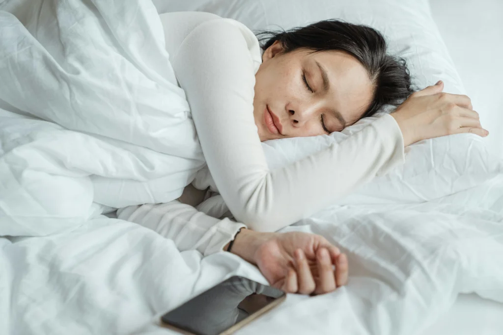 Mulher dormindo em uma cama aconchegante após sua rotina noturna.