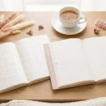 planner datado ou não datado abertos sobre mesa clara com flores e xícara de chá
